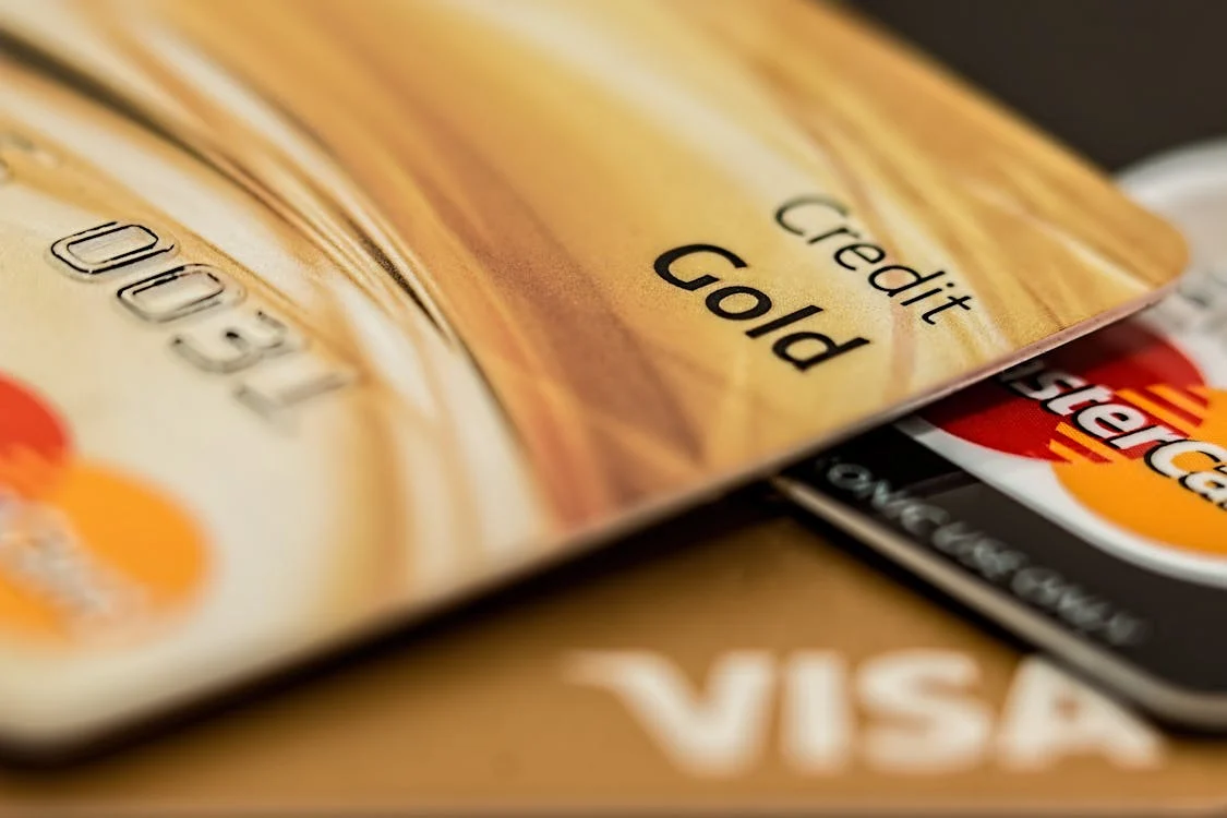 Two MasterCards and a Visa card stacked on top of one another; one card has its last four numbers visible and says "Credit - Gold". Fraud prevention is a concern for anyone doing credit repair services.