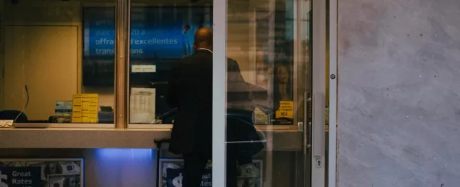 a man exchanges money at a local currency exchange retailer