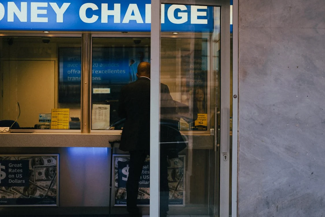 a man exchanges money at a local currency exchange retailer