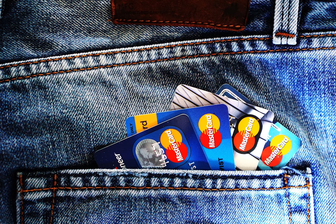 multiple MasterCards in the back pocket of a pair of jeans. chargeback protection for credit repair companies helps to keep them afloat by not being buried in legalities.